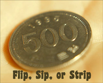 A flip a coin New Year's game called: Flip, sip or strip! Picture of a coin the palm of a hand.