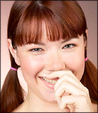 Pretty woman with pigtails giggling over birthday humor on birthday card.