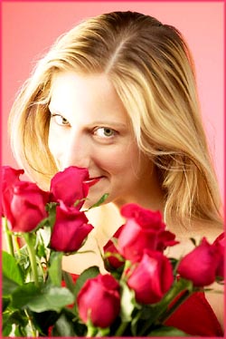 Happy birthday messages: Woman smelling red roses.