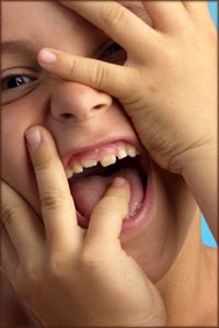 Little boy laughing while covering his face.