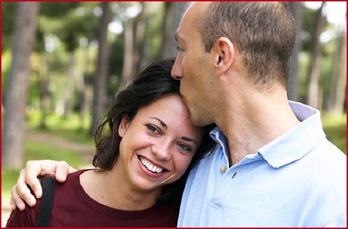 Man kissing woman's forehead. Happy woman smiling.