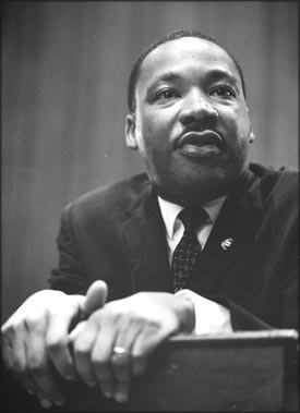 Photo of Martin Luther King leaning foreward on pulpit.