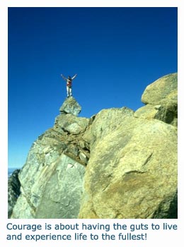 Picture of man on top of mountain rocks - message about courage and living life to the fullest