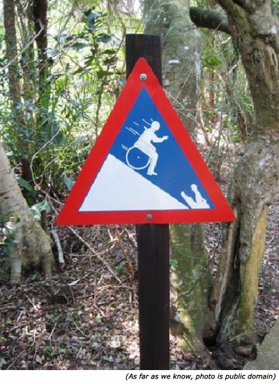 Silly signs: Funny handicap sign with man in wheel chair going down hill towards crocodile