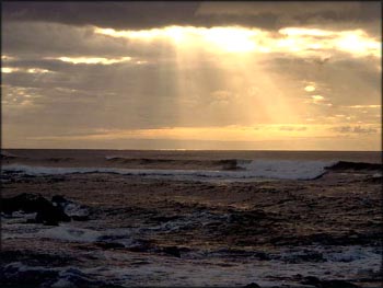 Feeling Gratitude: Sunshine penetrating dark clouds over the sea.