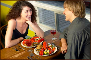 Ideas for dinner: Couple eating lobster in a cosy restaurant.