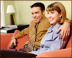 Valentine ideas: Couple sitting in sofa watching a movie.