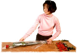 Woman florist arranging roses for a Valentine gift.