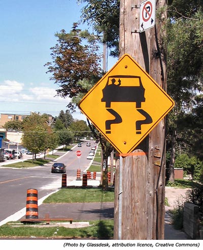 Funny road signs: A yellow sign with a drunk and inside a car and with a bottle in his hand.