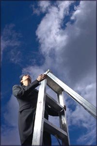 The sky is the limit: Woman climbing ladder with blue sky and clouds in the background.