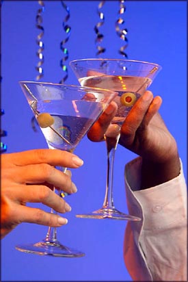 New Year Greetings and Toasts: Hands holding martinis and toasting to a happy new year.