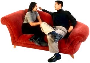 Talk about your resolutions for New Year with a loved one: Young couple talking in sofa.