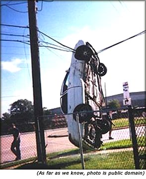 Funny car accident. Picture of car hanging in telephone wires.