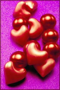 Lots of red plastic hearts on purple background. Short love poems inspiration.