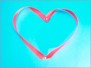Being thankful opens up your heart: Pink heart ribbon on blue background.