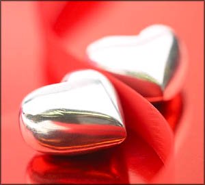 Two silver hearts on red background.