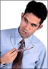 Man thinking while chewing on his glasses.
